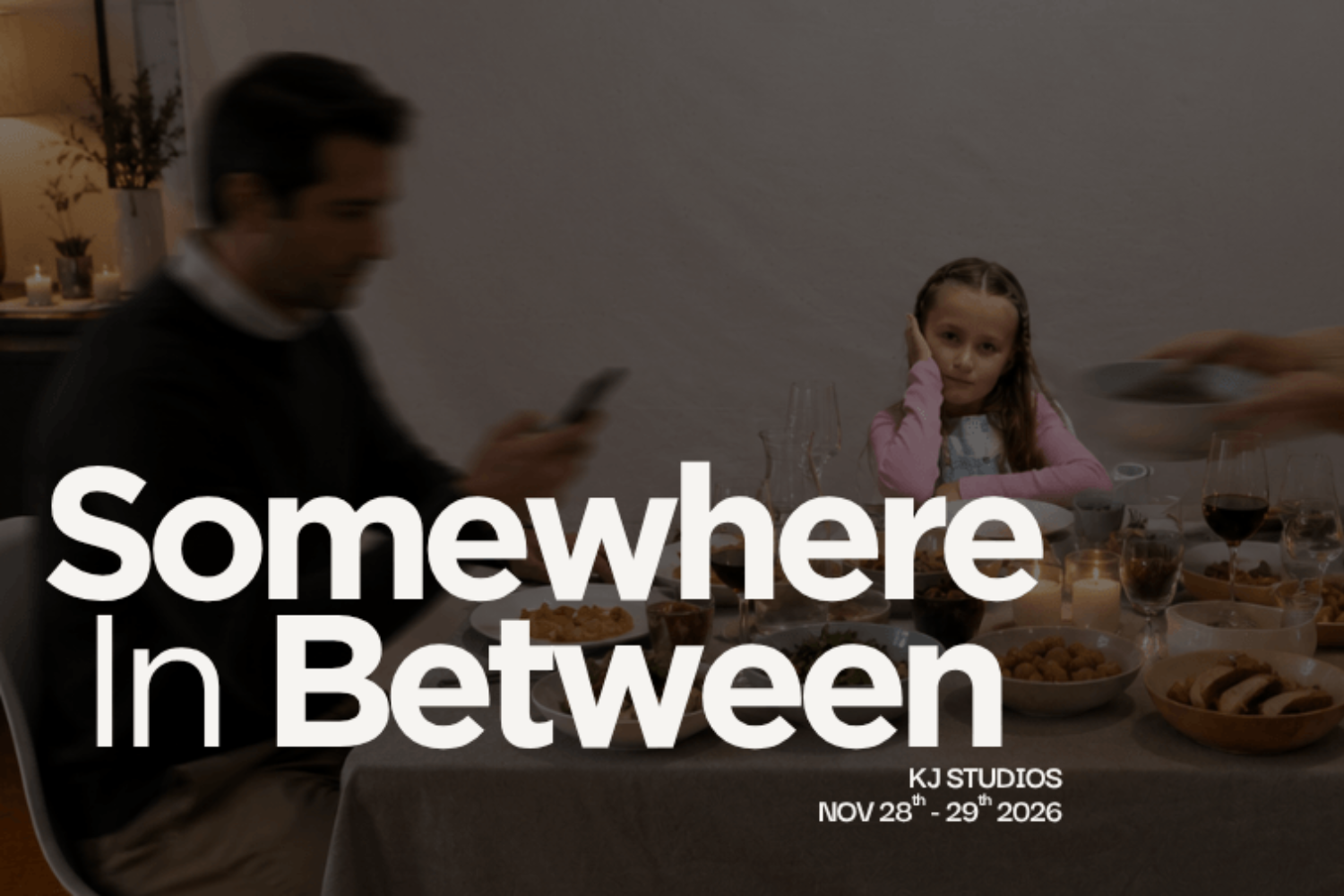 "Somewhere In Between" title in white text. A blurred man and a girl in a pink top sit at a level dining table with food and candles. KJ STUDIOS, NOV 28th-29th 2026. Dark grey colours.