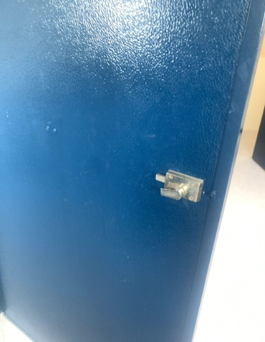 Blue, textured door with a metallic privacy latch. The latch is operated by a small lever.